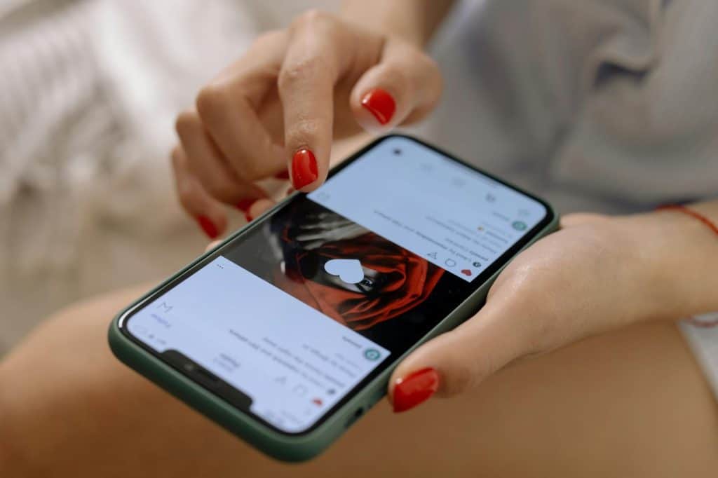 A woman holding a phone and looking at her post