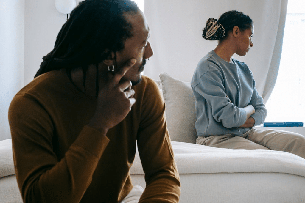 Black couple spending time on bed while having conflict