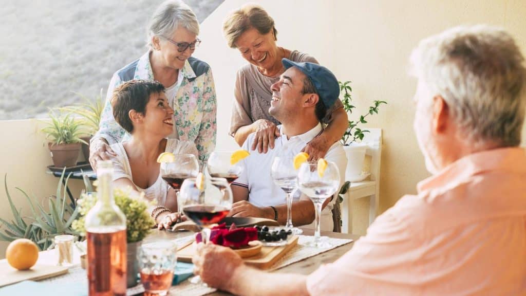 A group of seniors sharing food and drinks at an outdoor table.