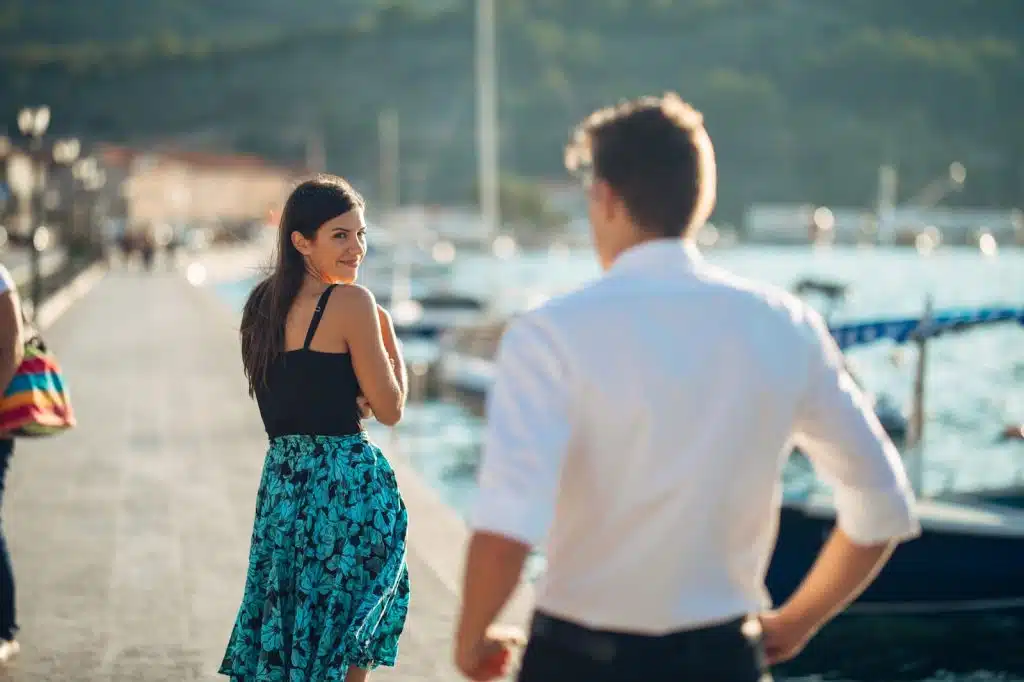 The woman is glancing over the man.