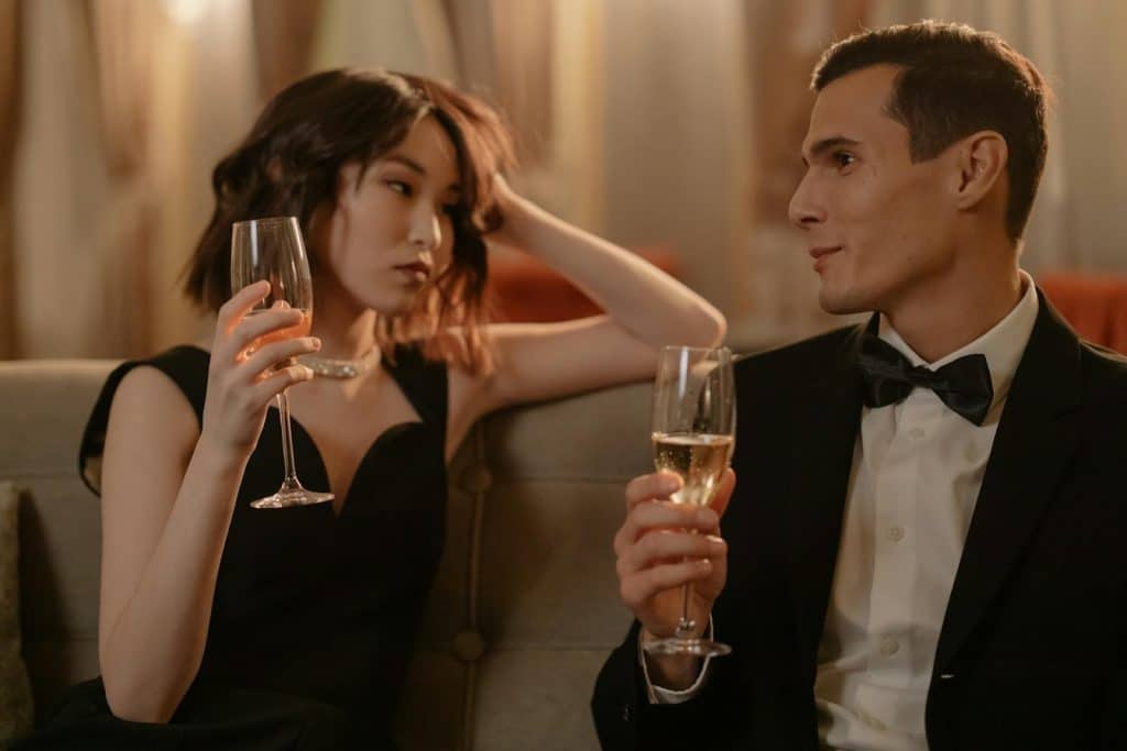 The woman in the black dress is listening to the man in a black suit.