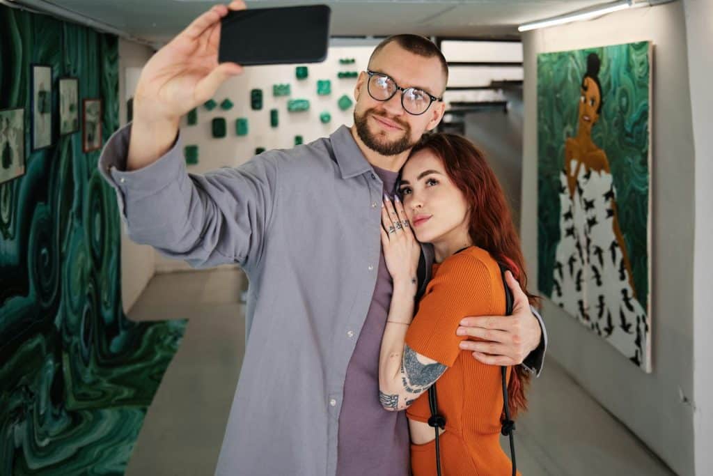 The man is taking a selfie with the woman.
