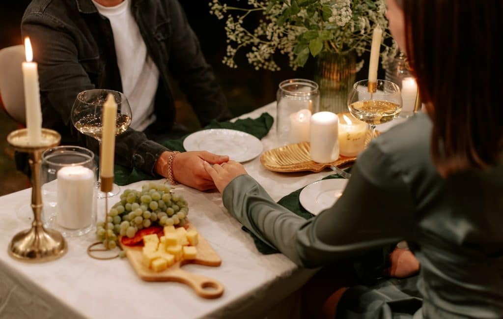 The couple is holding hands while on a dinner date.