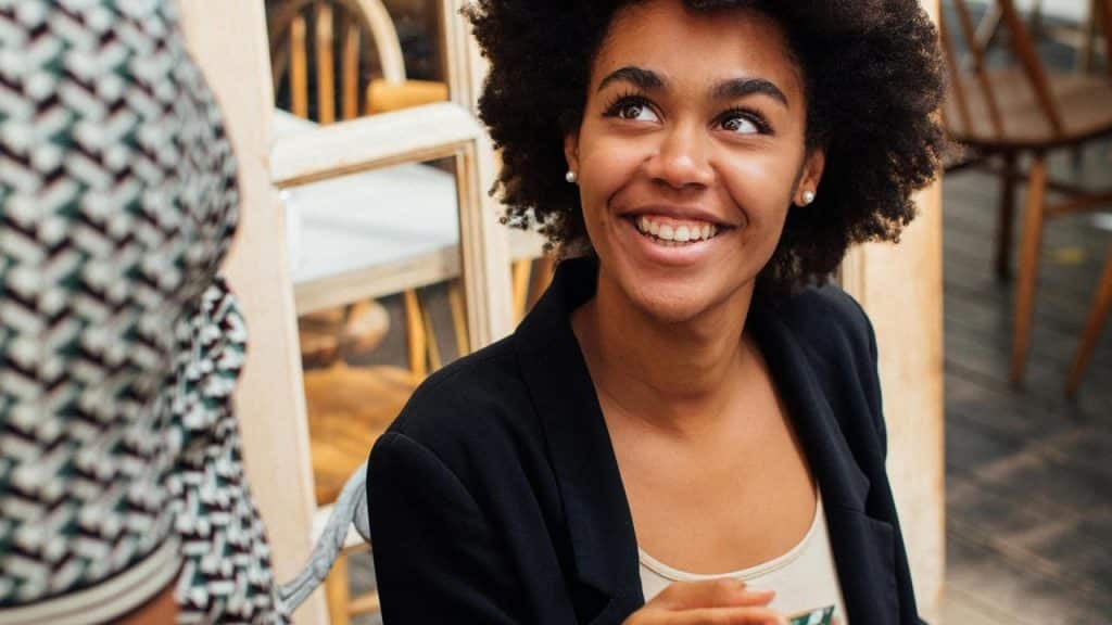 A woman smiling while talking to someone.