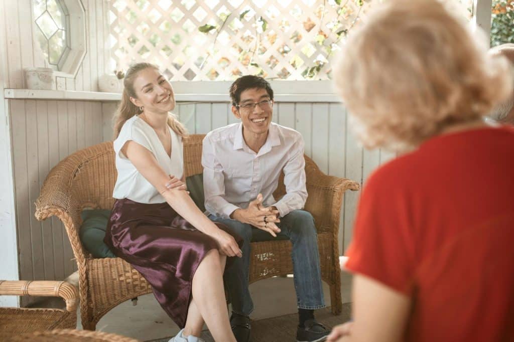 A man and woman listening to old couple
