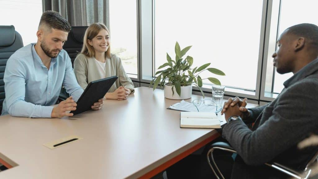A man being interviewed by two people in an office.