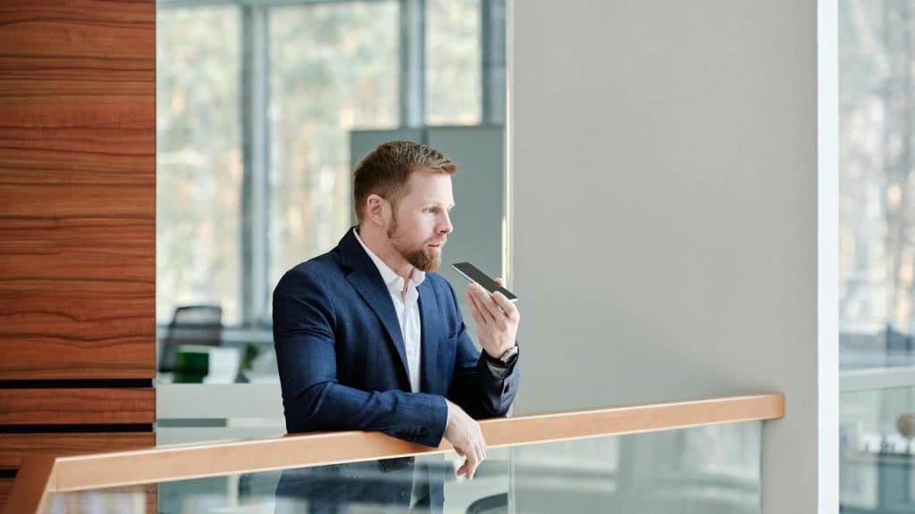 A man in a suit speaking into his phone.