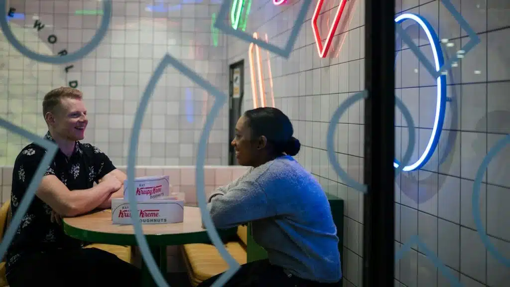 A man and woman talking in a cafe.
