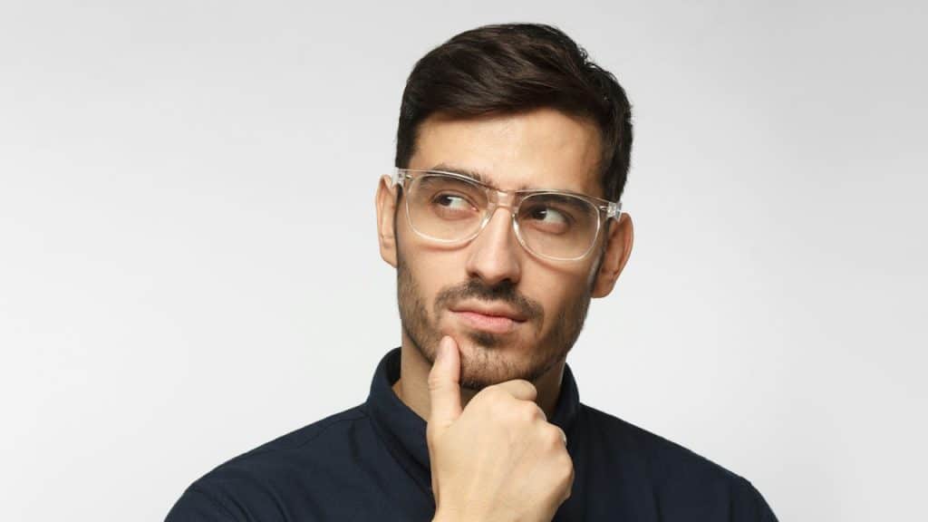 A bespectacled man thinking.