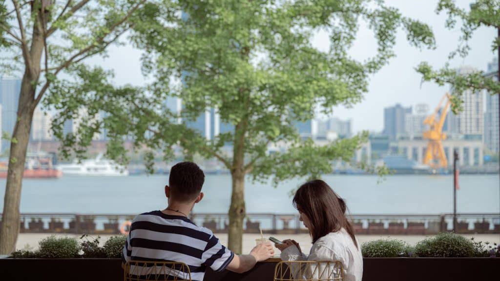 A man and a woman sitting on a bench.