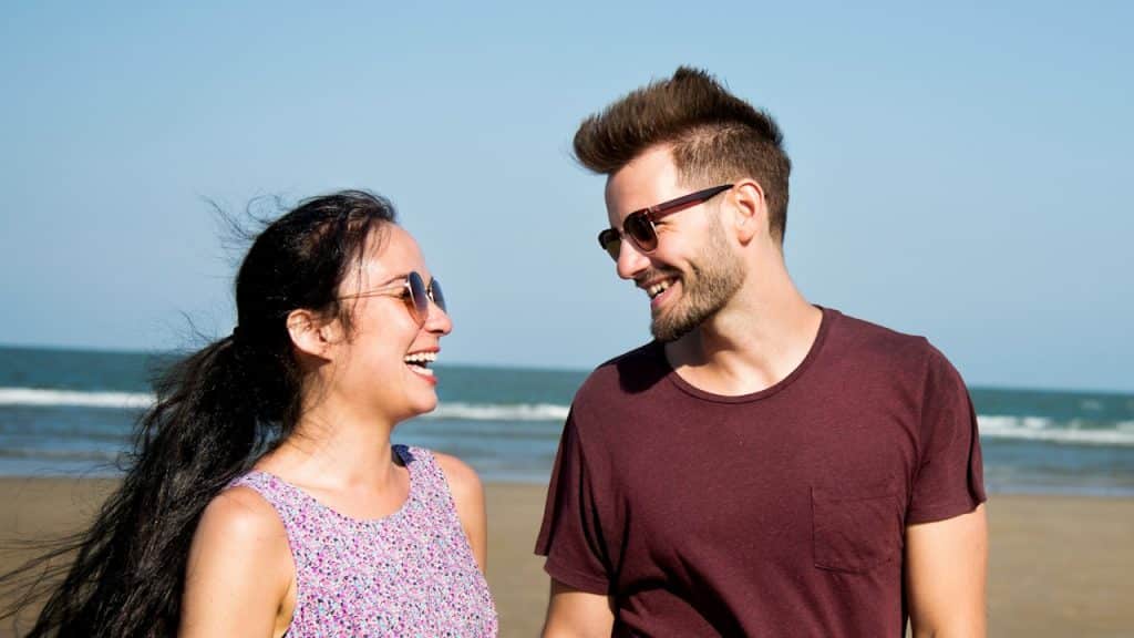 A couple walking on a beach.