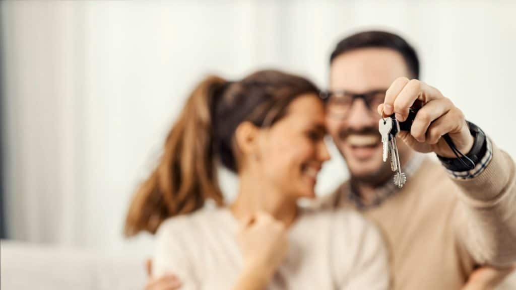 Husband holding keys of the new home for him and his wife.