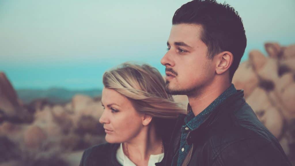 A couple looking to a side with a serious expression on their faces.