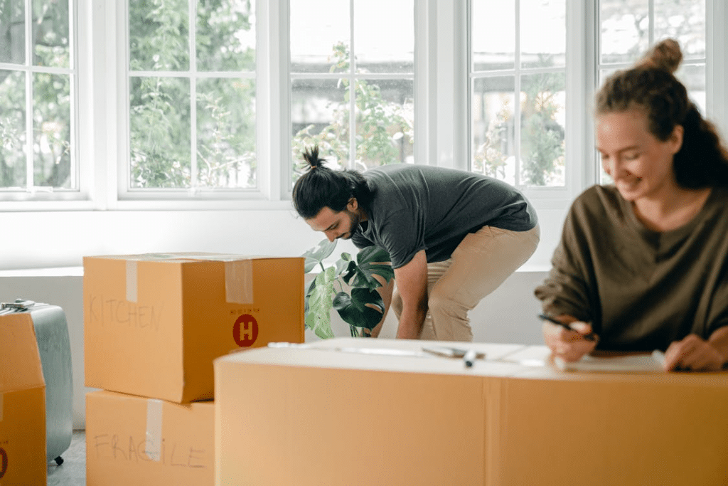 Happy young couple among boxes at new home