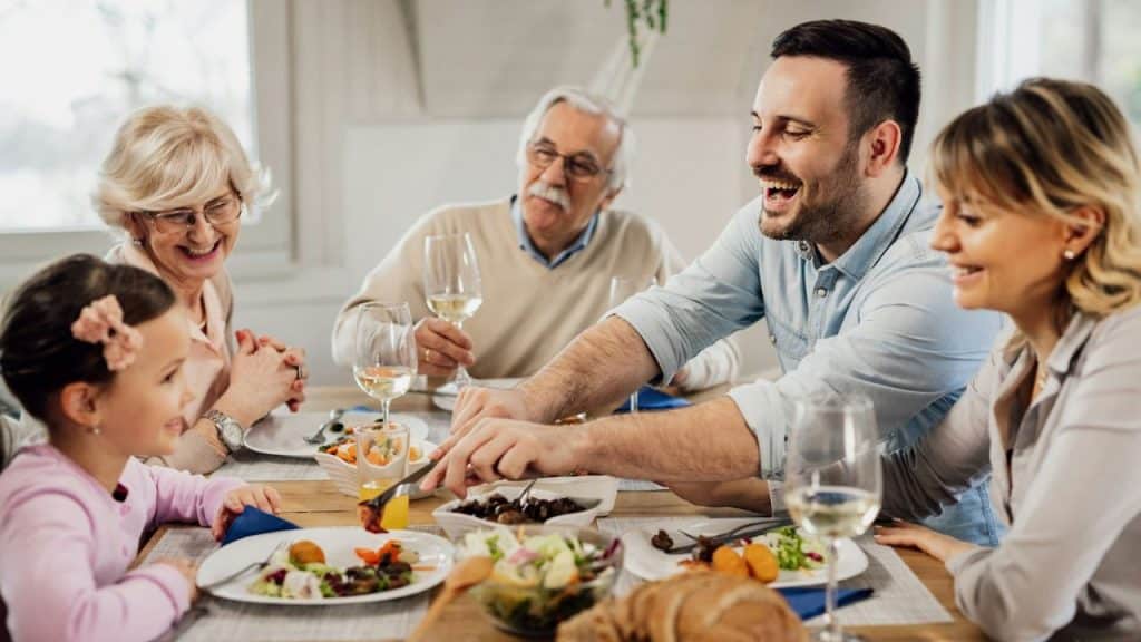 Smiling multi-generational family having a meal together at a dining table