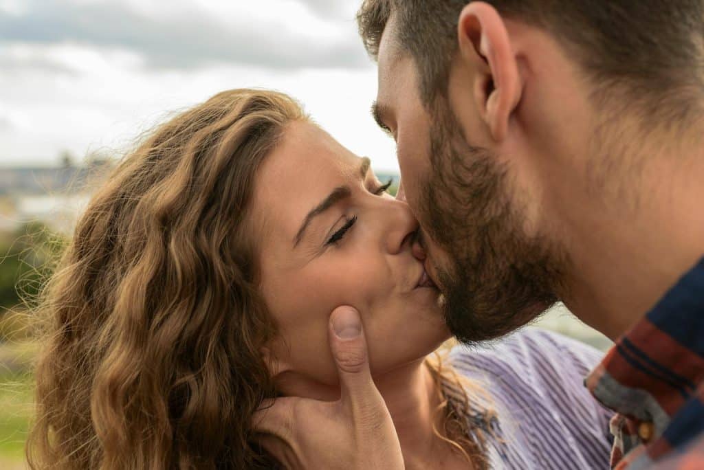 The man and woman are kissing each other.