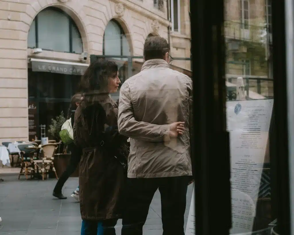 The couple is walking down the street.