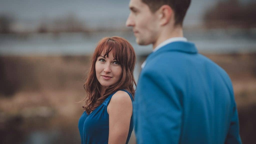 The woman is looking at the man in the blue suit when he’s not looking.