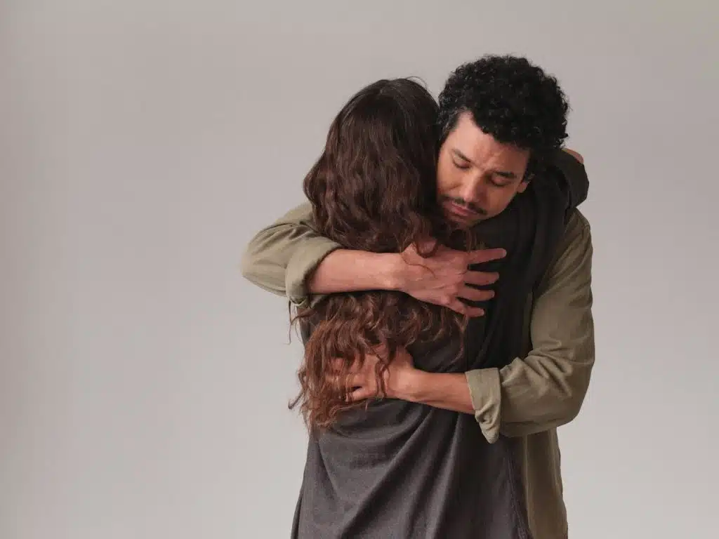The man is hugging the woman.