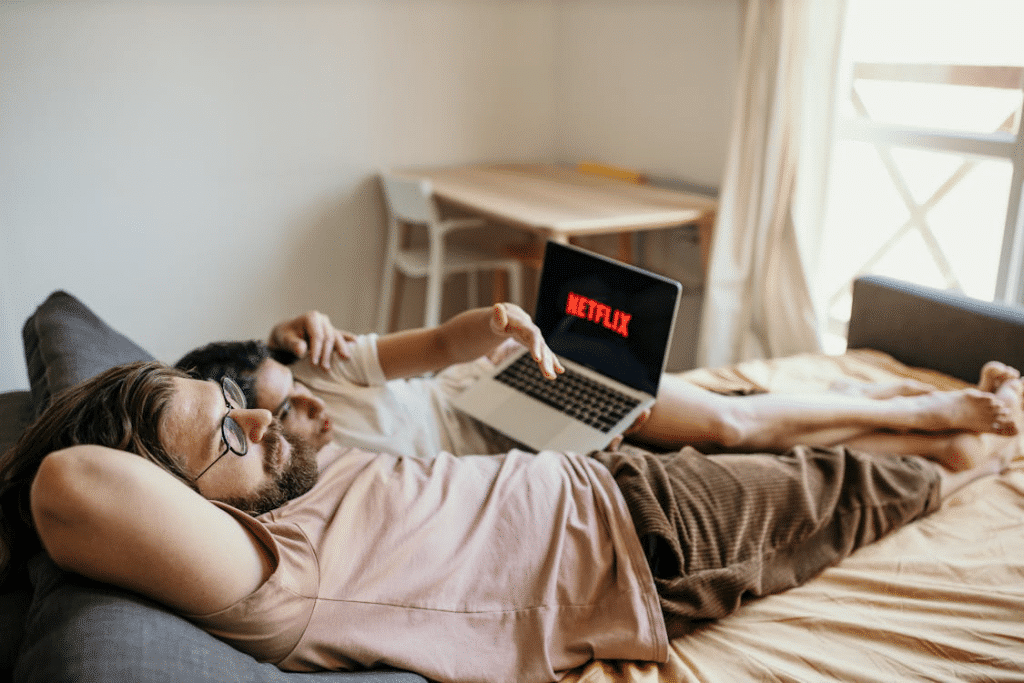 A Man in Orange Long Sleeves Sitting on The Sofa