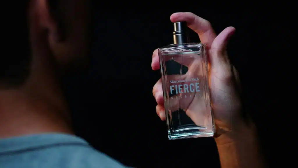 The man is spraying perfume.