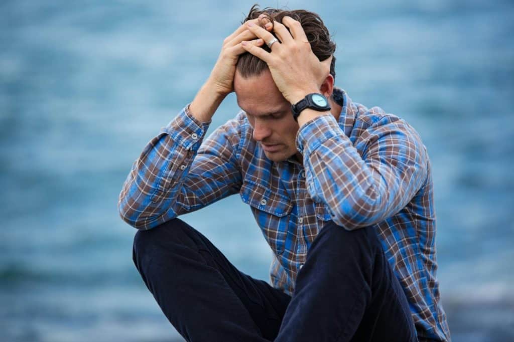 A man looking sad and holding his head