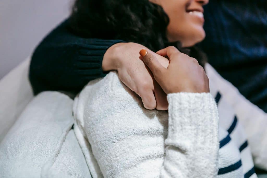 A man hugging and holding a woman’s hand