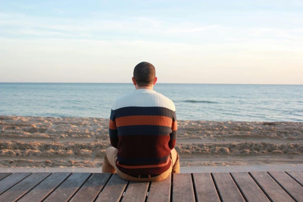 A man sitting alone and watching the view of ocean