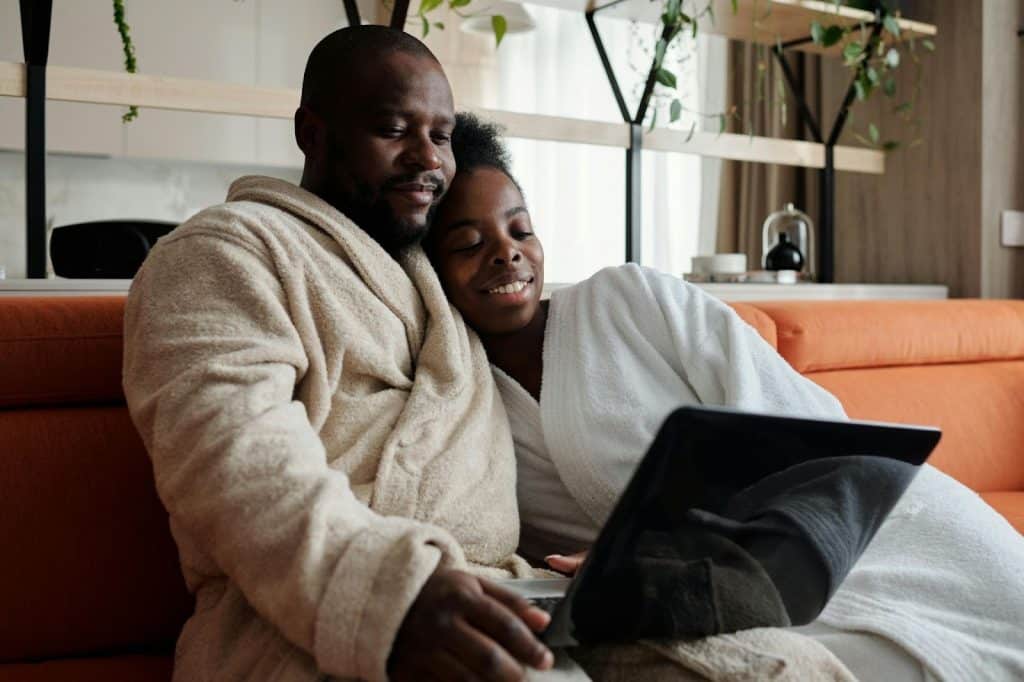 A man and woman watching at the laptop