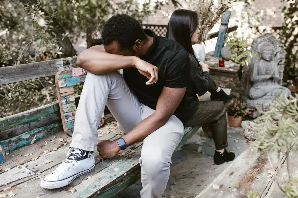 A sad man and a woman sitting behind him