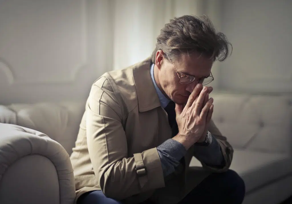 Sad mature businessman thinking about problems in the living room