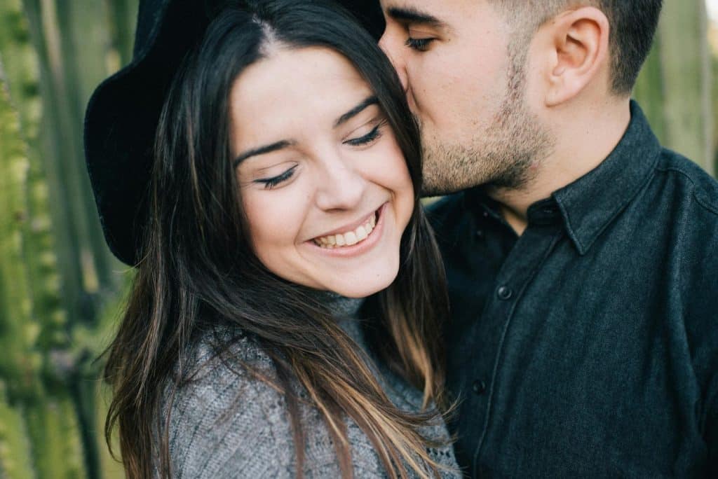 A man kissing a woman’s head