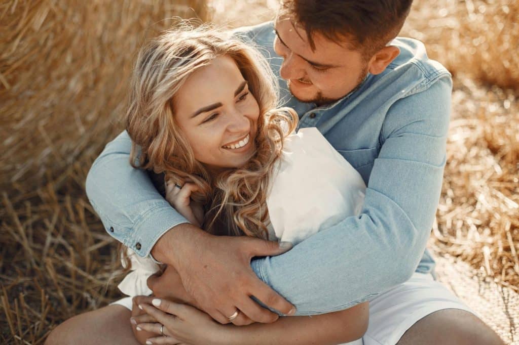 A man hugging a woman behind