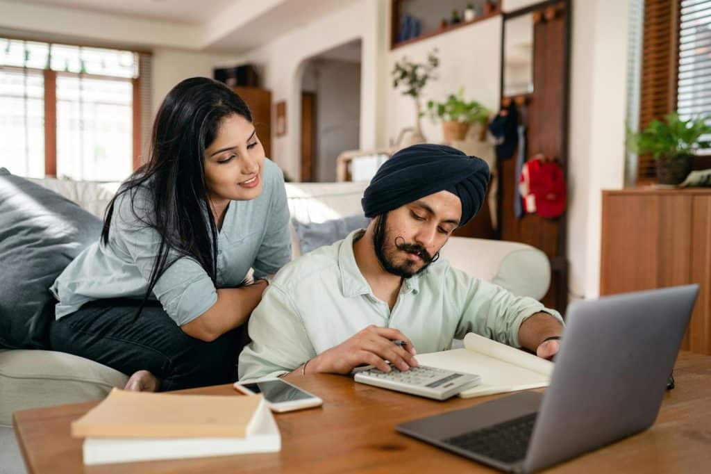 A woman watching a man to calculate finances