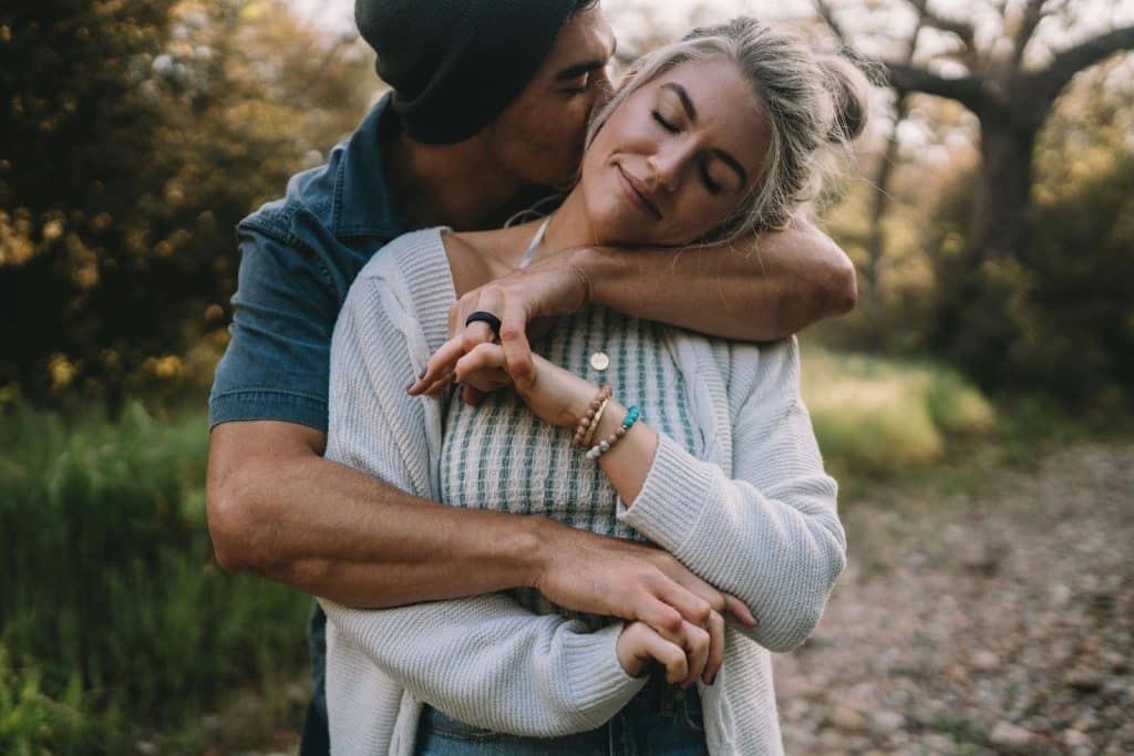 A man kissing woman’s neck