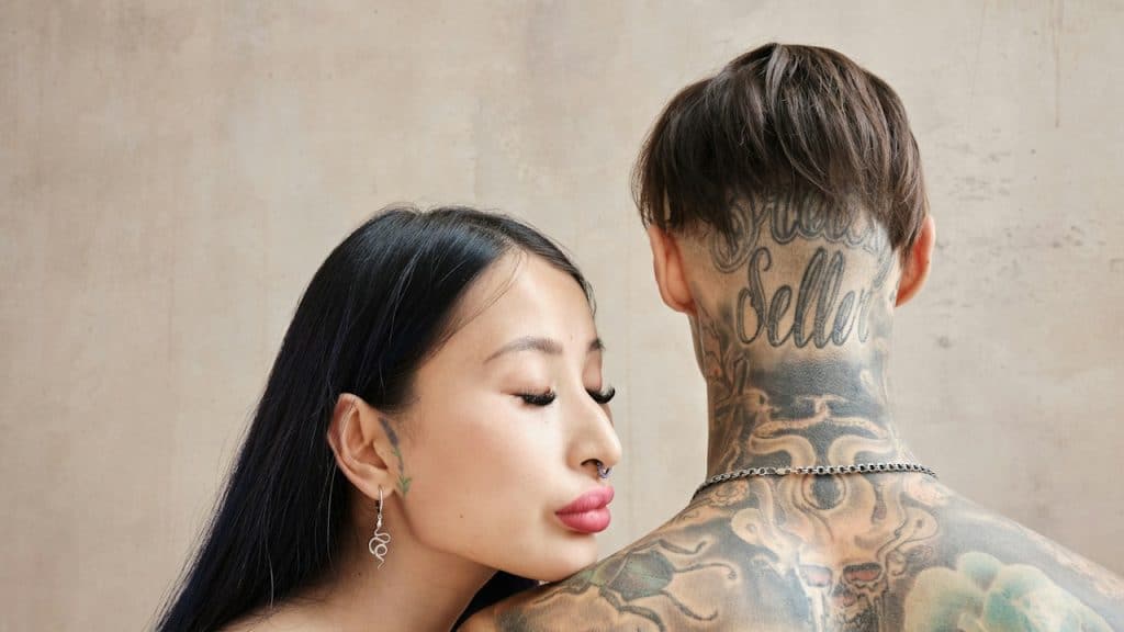 A man and woman with tattoos on their back.