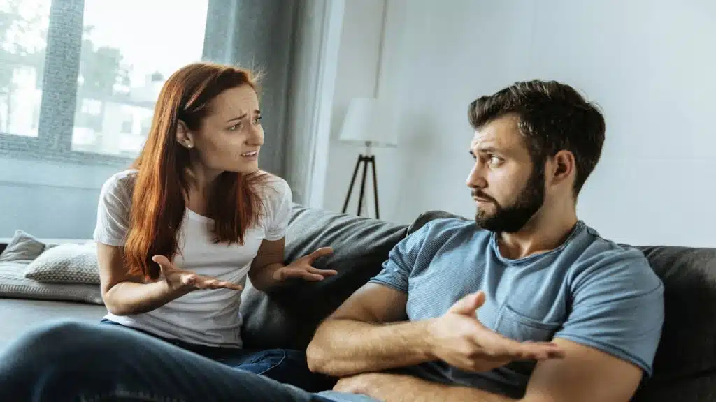 An unhappy woman complaining to her boyfriend about his attitude.