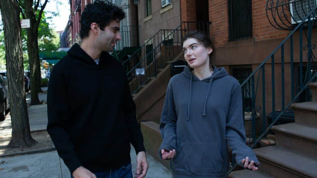 A couple walking down a street and talking.