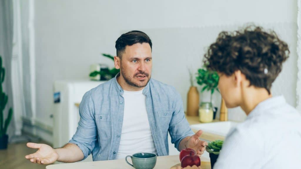 A man talking to his wife while having tea.
