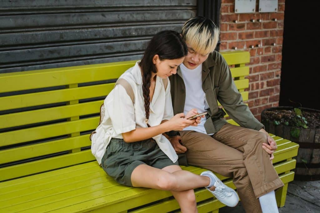 A man and woman sitting at the bench