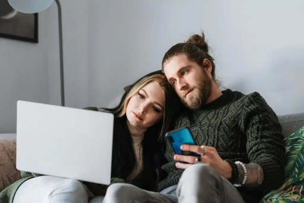 A man and woman looking at the laptop