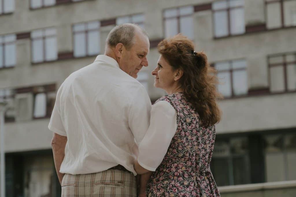 The couple is looking at each other while spending time outdoors.