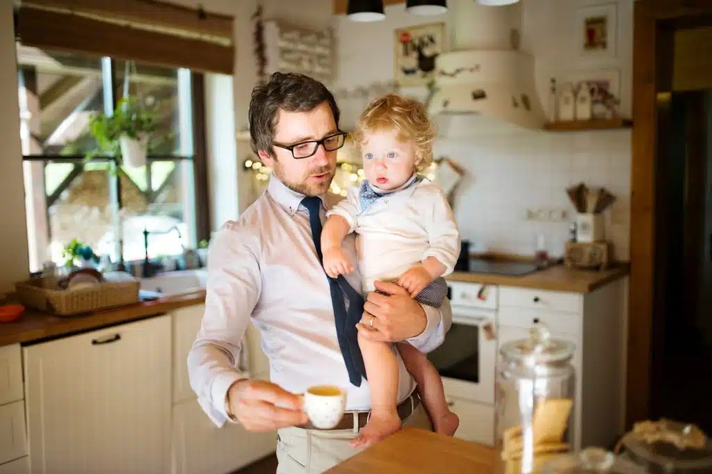 The man is holding his son in his arms.