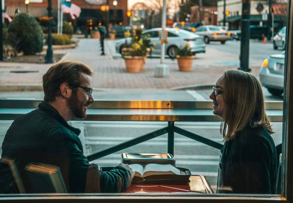 The man and woman are talking during the daytime.