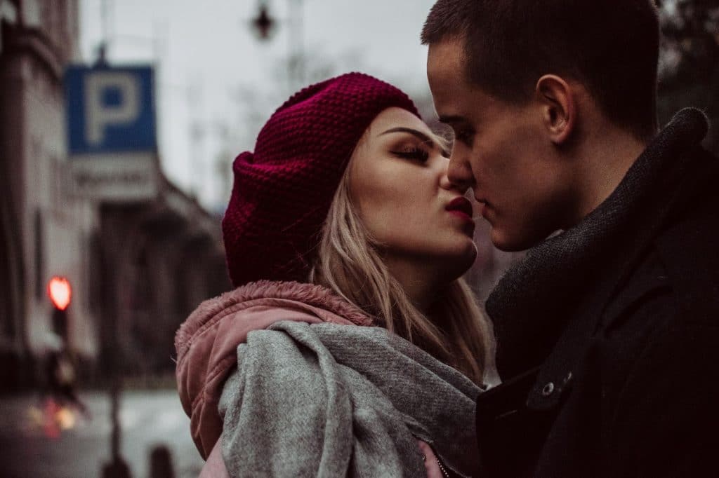 A woman kissing a man