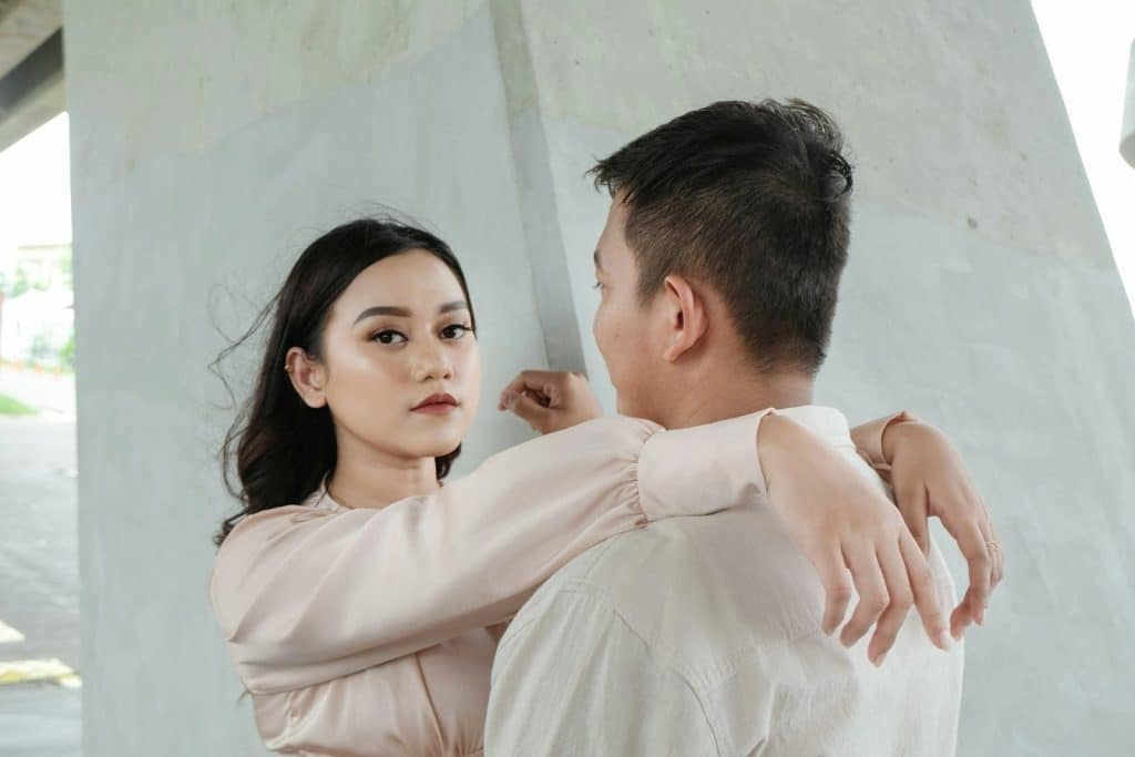 The man is looking at the woman while standing next to her.