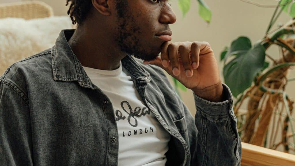 A person sitting with their hand on their chin, appearing thoughtful.
