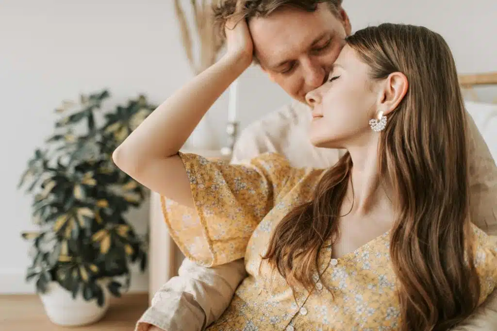 A man kissing a woman’s head