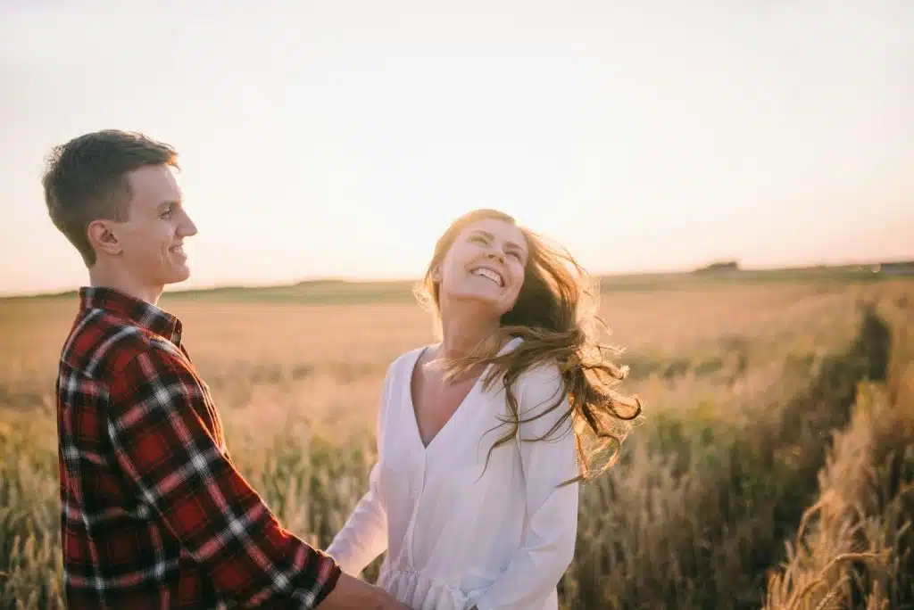 A couple standing in a grass field