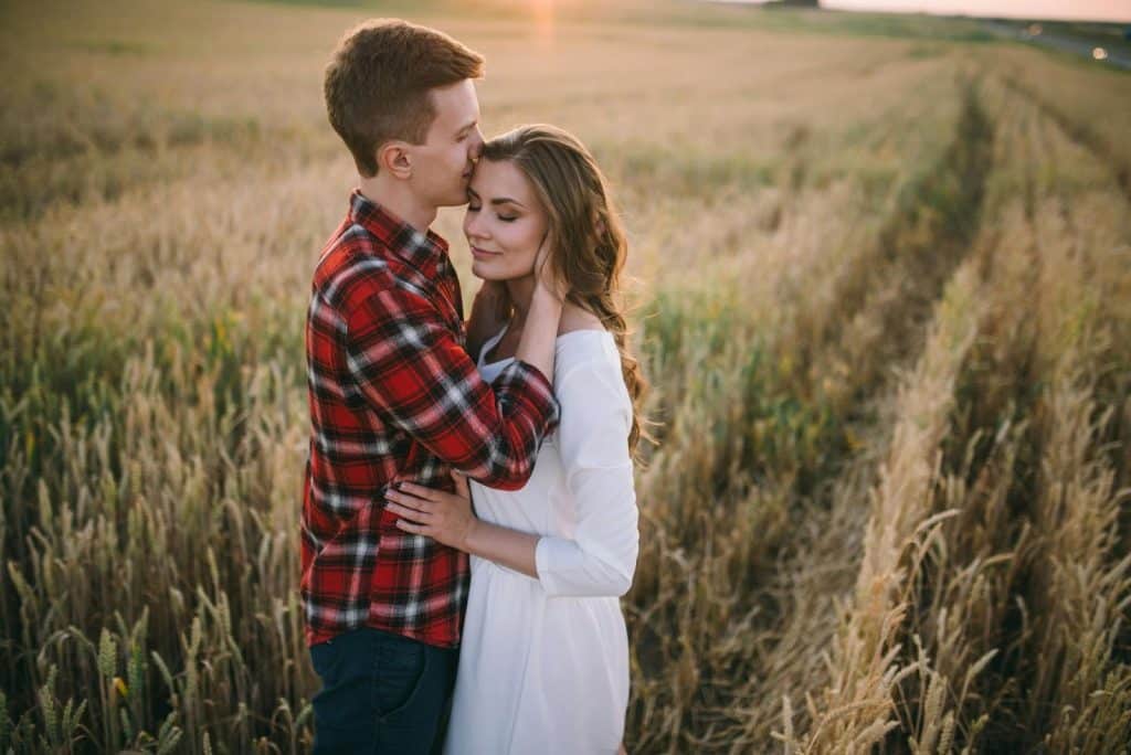A woman smiling while holding the husband’s hand